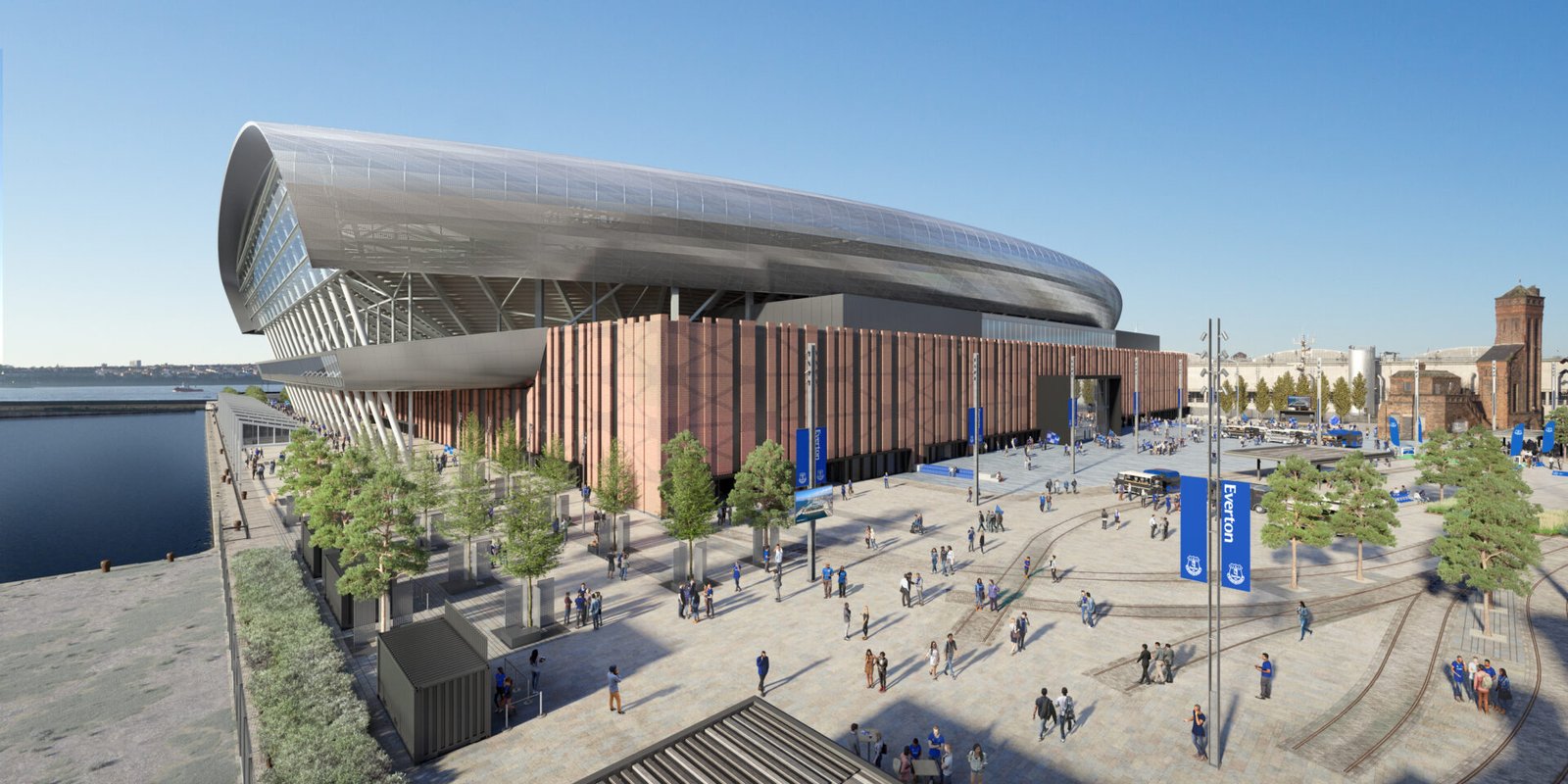 Precision craftsmanship has paved the way for the two halves of the expansive Fan Plaza at Everton Stadium to come together. So far, work on the 30,000m sq plaza has been undertaken in two sections, with the busy vehicle access road slicing through the middle. Now, following the relocation of all deliveries to the north end of the stadium, the specialist Laing O’Rourke stone contactors are fully-focused on combining the two paved sections to inch-perfect precision. Dave Ruddy, Project Manager for Laing O’Rourke, explained: “A lot of work is going into closing up the two halves of the eastern fan plaza. “We just recently shut down the main vehicle entrance to allow them to enter via the northern turrets, which enables us to close up the two halves. “The logistics of the overall scheme are quite difficult. There is a lot of activity on site at the moment and around 1,200 workers on site, along with multiple vehicle deliveries coming onto site every day, so it’s all about trying to maintain that equilibrium between keeping the job fed and keeping everyone safe.” A further level of complication sees the heritage assets being reinstalled as the plaza grows. That means many more of the historic railway lines, dating back to the dock’s heyday as a distribution point for goods heading into and out of Liverpool, being integrated into the final design. Ruddy added: “Firstly, we’re installing the reclaimed railway tracks, which is an important part of the heritage compliance scheme. “So far we have installed about 1,800 linear metres and it’s like a massive jigsaw involving very difficult and heavy items, so we’re reliant on machinery to place them, but it’s a testament to the skill of the workers as to how straightforward that process has been. “There’s a high emphasis on the engineering part of that, in terms of setting it all out and ensuring it fits in where it should, and when that is complete you will start to see the paving close in around them, which in term frees up the installation of furniture and the completion of the street lighting columns.” Skilled craftsmen from Vetter, who are part of the Laing O’Rourke group of companies, have worked diligently through all that the weather could throw at them during the 52-week programme to create the fan plaza. And Ruddy is full of praise for the workforce in keeping the landscaping scheme firmly on track for completion in late summer. He said: “It’s a testament to their skill, particularly those working in the external realm. “There is no protection out there from the elements and they are out in it from 7.30am to 6pm, so you do feel for them sometimes. “There is a still lot of interface with all that is happening with the stadium façade and barrel cladding to the roof being installed, so we have to get the timing just right, so that we don’t put the paving in too early and run the risk of damaging it through either the cranes, or heavy plant. “But they thrive on it and just love getting stuck in and getting the work done to the standard required for this job.”